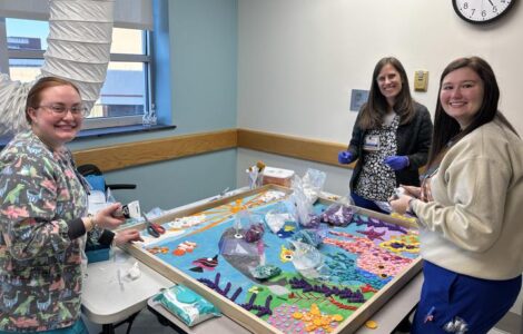 Nursing tech Kristin King and nurses Mona Schlawinsky and Lakyn Blanton take a few minutes to help bring the narwhals to life.