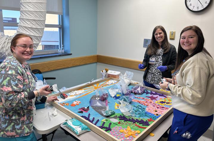Nursing tech Kristin King and nurses Mona Schlawinsky and Lakyn Blanton take a few minutes to help bring the narwhals to life.