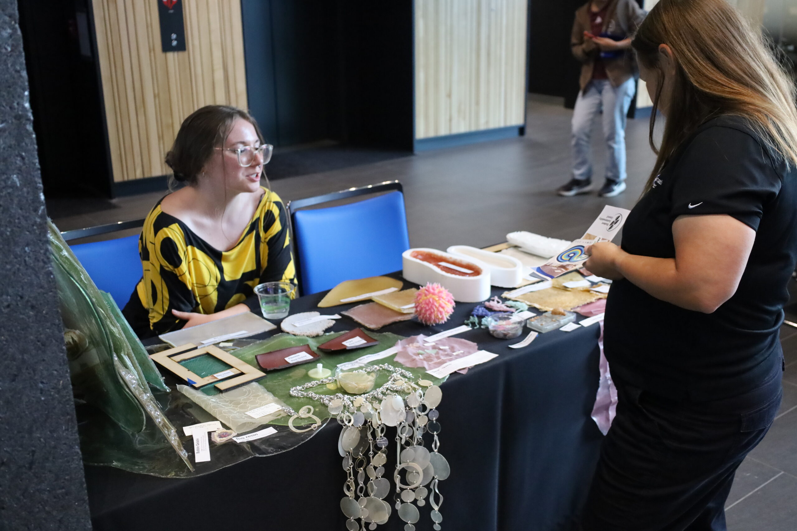 Women tables at vendor fair showcasing bioplastics