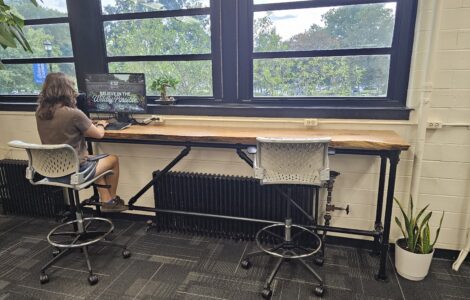 Student works on computer at countertop in an office